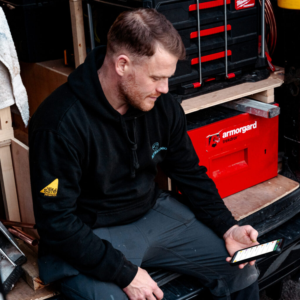 tradesperson using automatic reminders on Powered Now